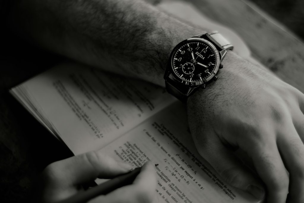 Man met horloge schrijft; schrijftijd
